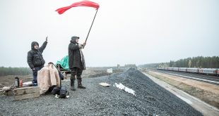 Attivisti sventolano una bandiera mentre passa il treno