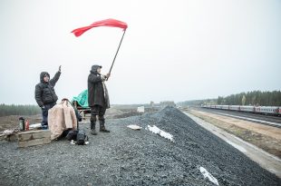 Attivisti sventolano una bandiera mentre passa il treno