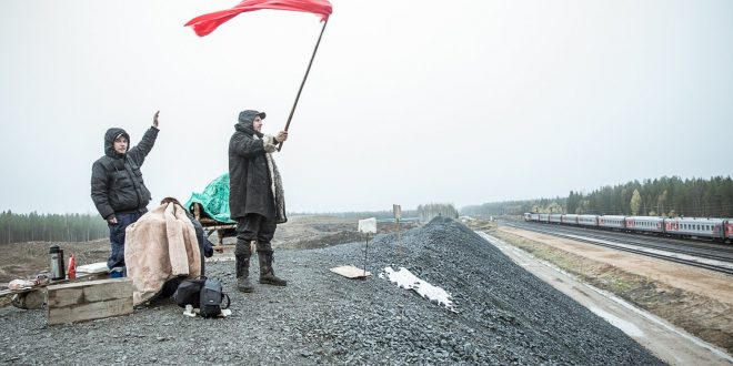 Attivisti sventolano una bandiera mentre passa il treno